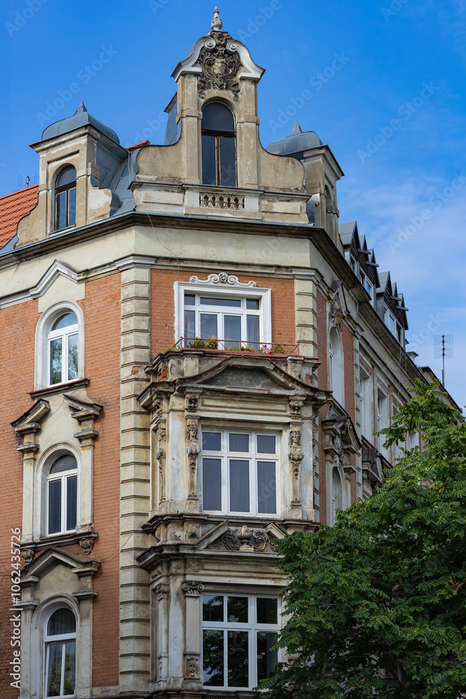 Historic European building facade with intricate architectural details, vintage windows and a beautifully preserved corner design under a bright blue sky. Heritage and classic architecture Historic European building facade with intricate architectural details, vintage windows and a beautifully preserved corner design under a bright blue sky. Heritage and classic architecture