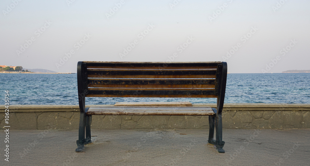 Empty bench facing the sea, symbolizing solitude and peaceful moments. Empty bench facing the sea, symbolizing solitude and peaceful moments.