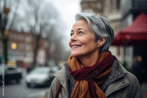 Portrait of a smiling senior woman walking in the city street.