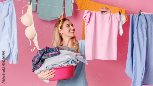 Smiling housewife hangs clean clothes near cleaning supplies, free space