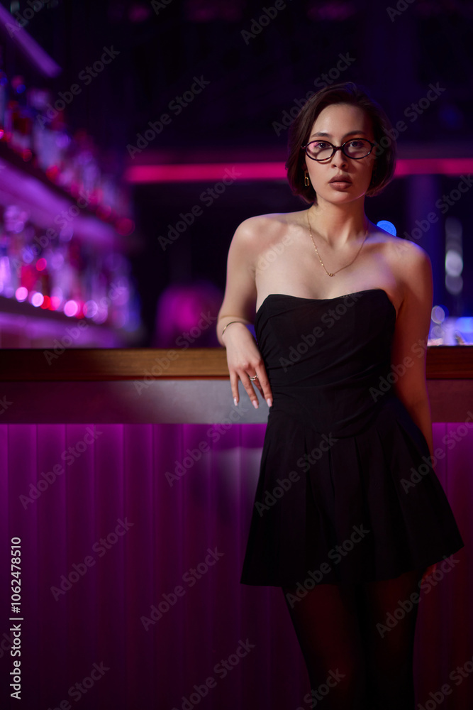A stylish woman struts into the bar at night, exuding elegance and seduction of nightlife A stylish woman struts into the bar at night, exuding elegance and seduction of nightlife