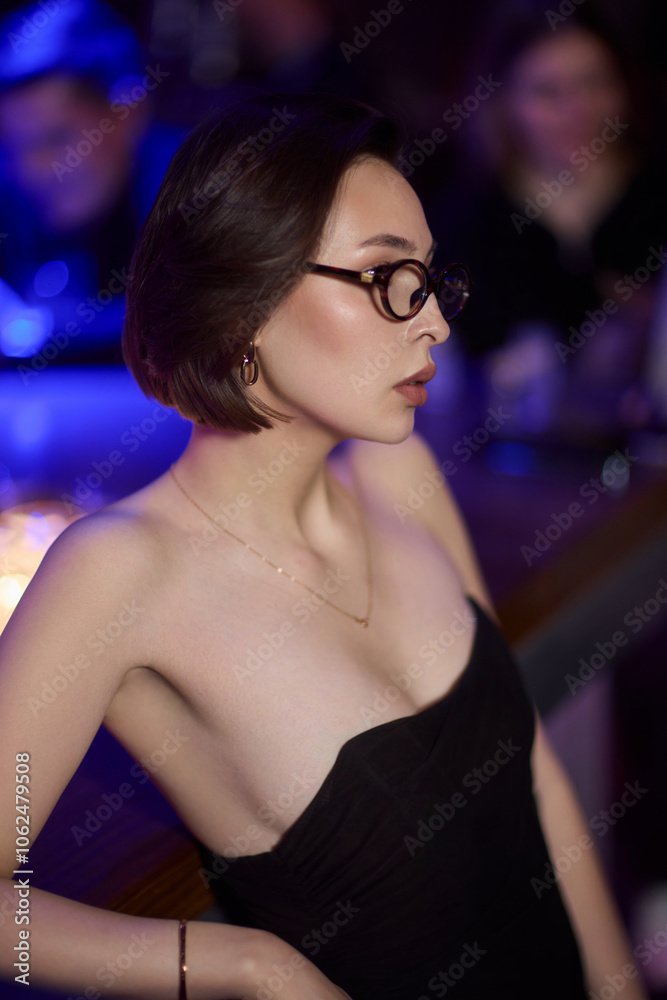 A stylish woman struts into the bar at night, exuding elegance and seduction of nightlife A stylish woman struts into the bar at night, exuding elegance and seduction of nightlife