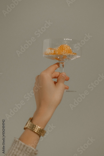 person hand with glass of tangerines