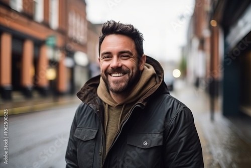 Portrait of a handsome man smiling in the city. Urban scene.