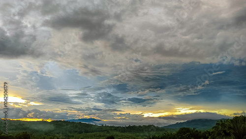 A breathtaking sunset with vibrant purple and orange hues spread across the clouds, overlooking a serene, mountainous landscape.