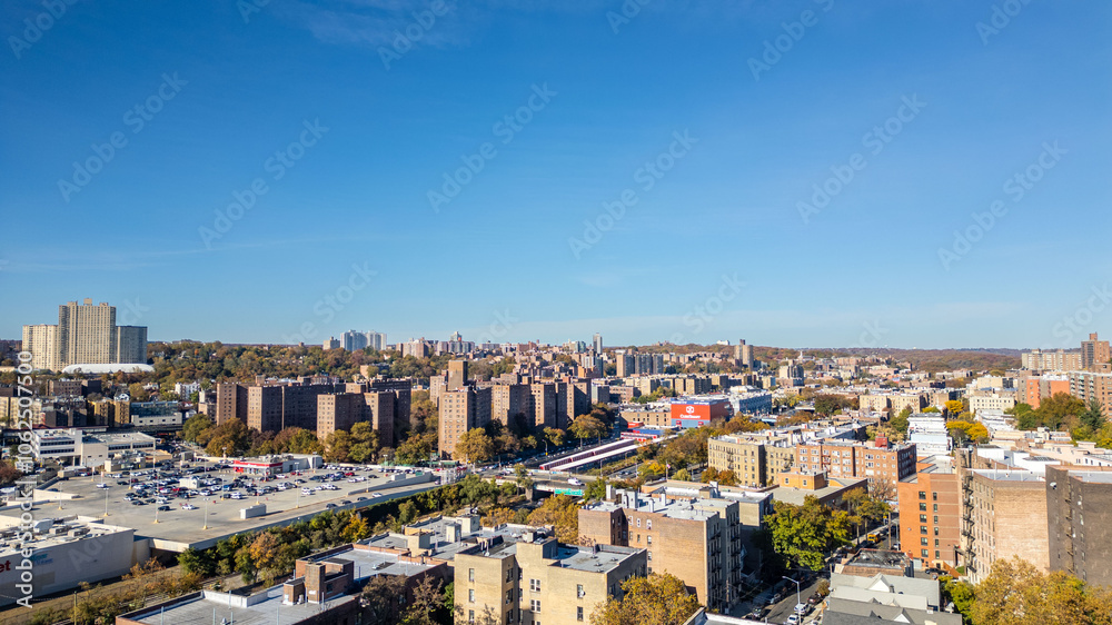 Obraz premium This location in the Bronx offers stunning views of lush greenery, a picturesque lake, and urban structures. Framed by the river, it showcases iconic bridges and the New York City skyline 