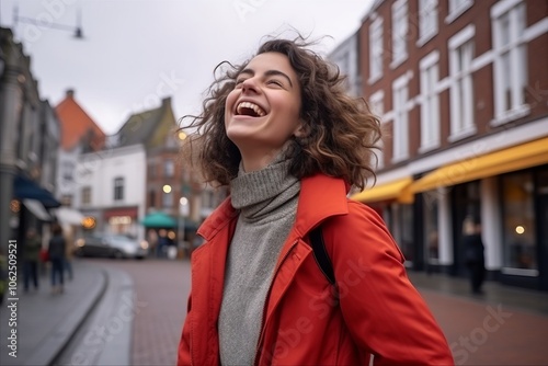 Portrait of young beautiful woman in red coat walking on city street