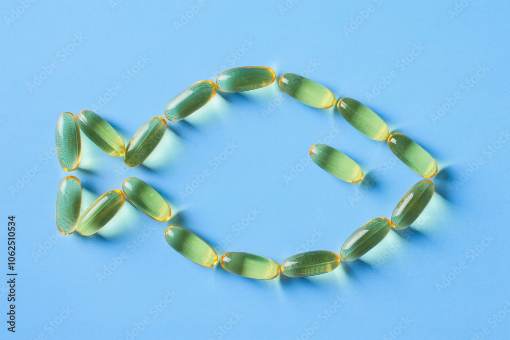 Fish made of Omega-3 fish oil capsules on a blue background. Ideal for health, wellness, and nutrition themes Fish made of Omega-3 fish oil capsules on a blue background. Ideal for health, wellness, and nutrition themes