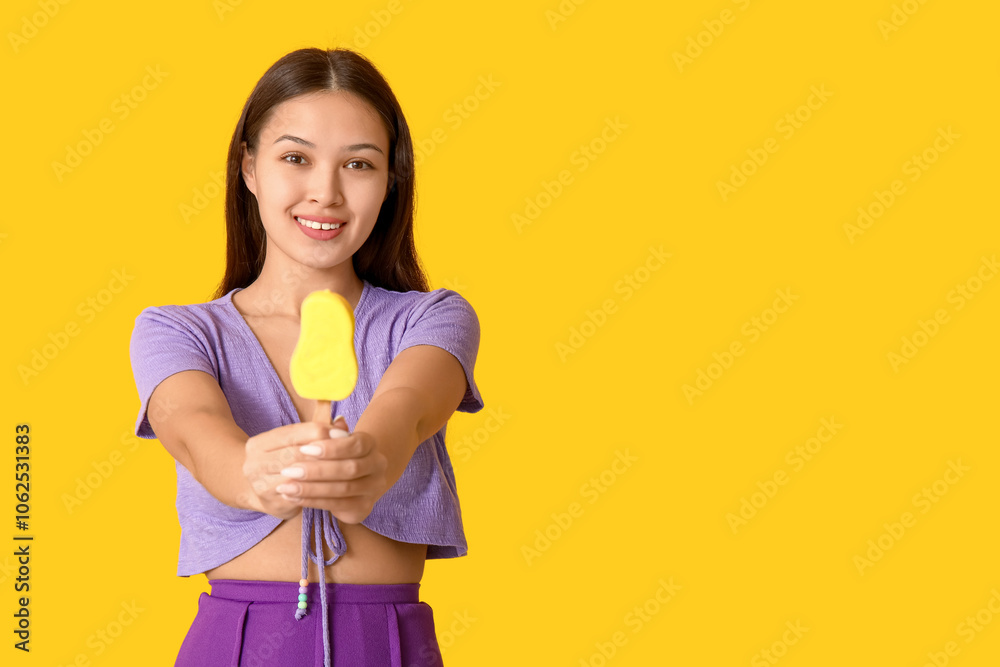Beautiful Asian woman with mango ice-cream on yellow background Beautiful Asian woman with mango ice-cream on yellow background