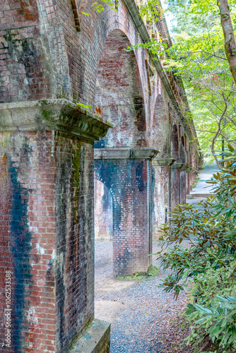 An old Japanese aqueduct surrounded by beautiful greenery.