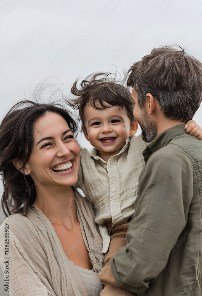 family photo of an attractive woman in her thirties, laughing and holding up her toddler boy with dark hair in the air, wearing a beige dress and green shirt family photo of an attractive woman in her thirties, laughing and holding up her toddler boy with dark hair in the air, wearing a beige dress and green shirt