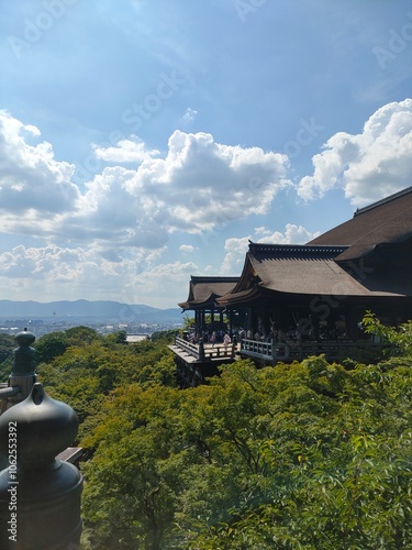 The mesmerizing temple balcony is poised gracefully amidst nature's lush green embrace, under a sky painted with clouds, offering tranquility and inspiration.