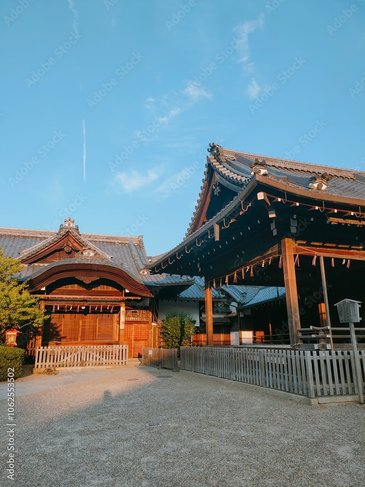 Naklejka premium An intricate display of traditional wooden architecture is captured under the warm glow of sunlight, highlighting the quaint artistry and timeless construction of the era.