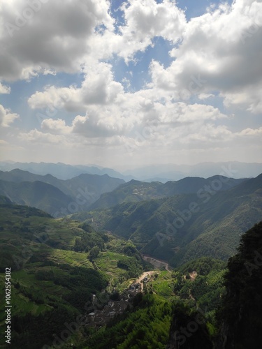 This scene depicts majestic mountains and intertwining valleys under a softly lit sky, creating a stunning panorama of beauty and harmony with nature.