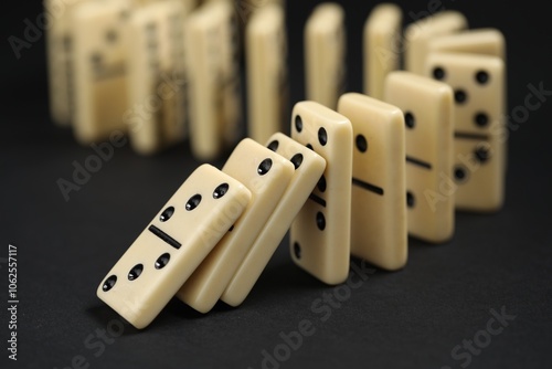 Domino effect. Tiles falling on black background, closeup photo