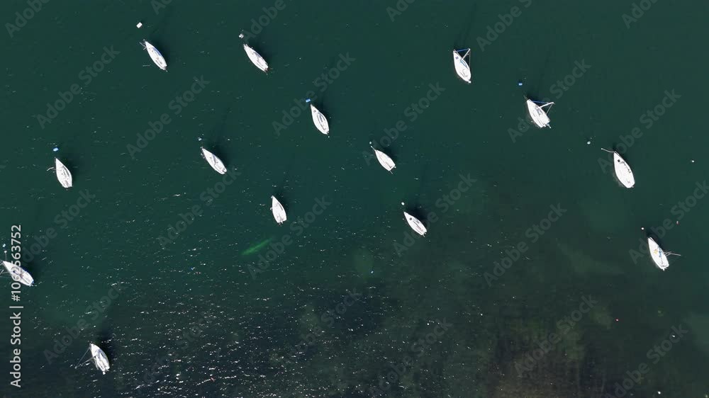 Aerial top-down image of several boats anchored in a lake. Aerial top-down image of several boats anchored in a lake.