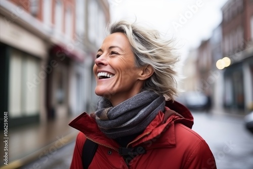 Portrait of a middle-aged woman laughing in the city.