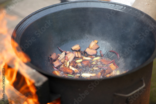 Stir-fried pork belly in a wood-fired iron wok photo