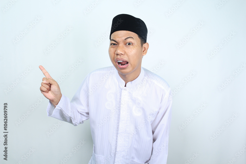 confused asian muslim man pointing to side isolated on white background confused asian muslim man pointing to side isolated on white background