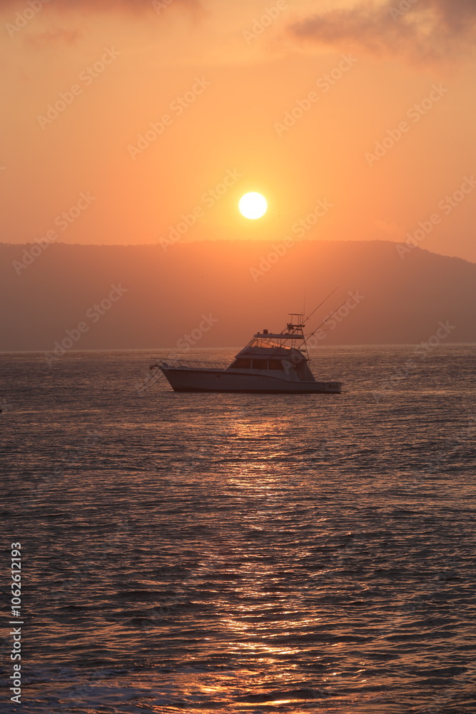 Beach sunrise: orange sky, calm sea, boat, captivating beauty in nature. Beach sunrise: orange sky, calm sea, boat, captivating beauty in nature.
