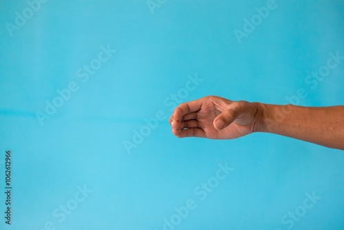 A man's hand with a pose or gesture of holding or showing something on a blue background