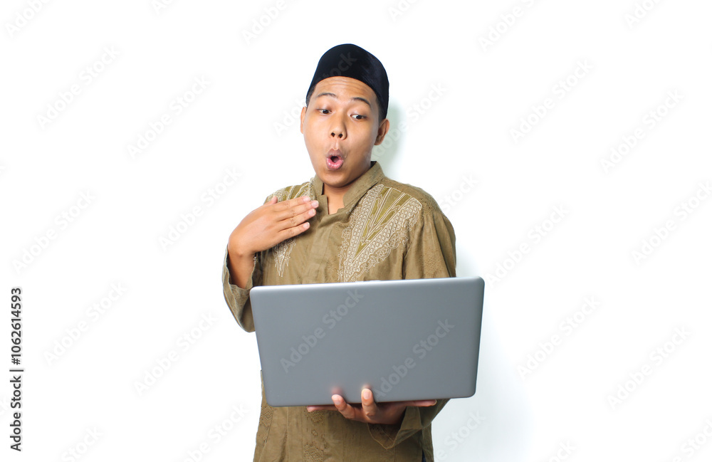 surprised asian muslim man holding laptop with touching his chest isolated on white background surprised asian muslim man holding laptop with touching his chest isolated on white background