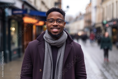 Portrait of a handsome african american man wearing coat and scarf in the city