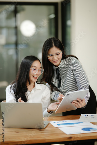 Asian business woman talking, working on graph documents
