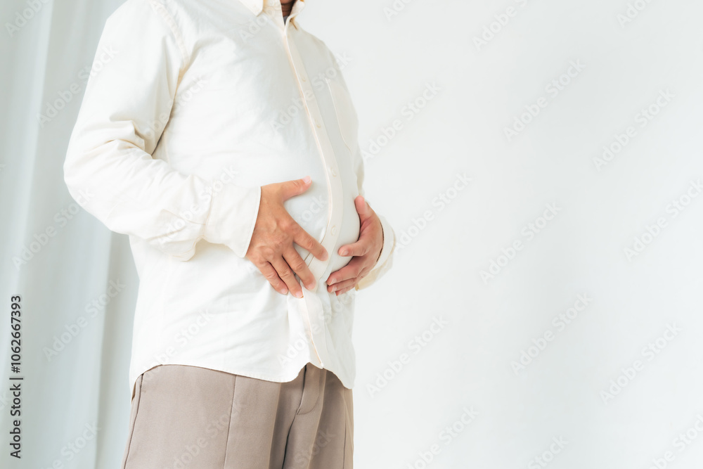 Naklejka premium お腹、太る、肥満、メタボ、中年太り、ダイエット、男性、内臓脂肪、満腹、脂肪、中年、中高年、ミドルエイジ、日本人、ぽっちゃり、生活習慣病、健康、ヘルスケア、体重、カロリー、運動不足、食べ過ぎ、シニア、老化、デブ、メタボリックシンドローム、腹囲、BMI、エンゲル指数、腹痛、コピースペース、皮下脂肪、ぽっこり、過食、加齢、食生活、基礎代謝、ホルモンバランス、食欲、飽食、メディカルダイエット、糖尿病、高血