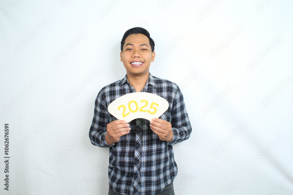 isolated happy asian man celebrating new year eve with holding 2025 card wearing casual clothes isolated happy asian man celebrating new year eve with holding 2025 card wearing casual clothes
