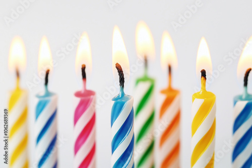 Colored thin burning birthday candles. White background. Holiday candles for cake. Happy birthday card.