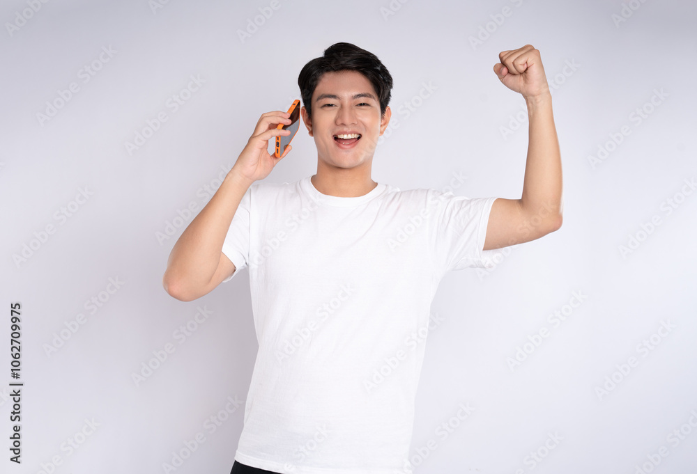 Fototapeta premium Portrait of young asian man using phone on white background 
