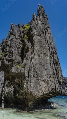 Photography A picturesque karst rock against a background of blue sky and turquoise ocean