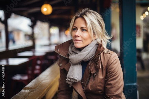 Portrait of a beautiful woman in a coat and scarf at the cafe