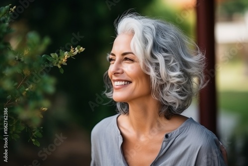Portrait of a beautiful middle aged woman with gray hair smiling outdoors