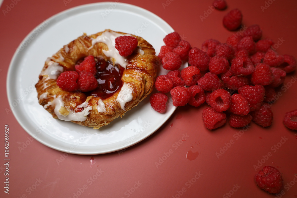 Delicious sweet dessert with raspberry on the white plate and red background 