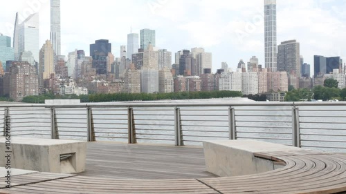 New York City waterfront skyline, Manhattan Midtown buildings, riverfront skyscrapers by East river water. Waterside cityscape, Gantry Plaza Park, Long Island, Queens, United States. Riverside bench. photo