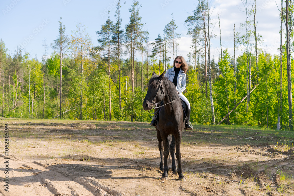 Woman is riding a horse in a forest Woman is riding a horse in a forest