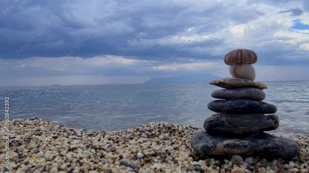 Serene Stack of Stones on Beach: Balanced Rock Tower by the Ocean with Peaceful Waves and Blue Sky Serene Stack of Stones on Beach: Balanced Rock Tower by the Ocean with Peaceful Waves and Blue Sky