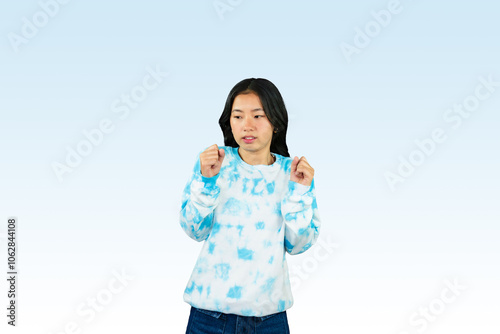 Yougn Asian girl with blue dress points and gives various expression and gestures isolated happy sad photo