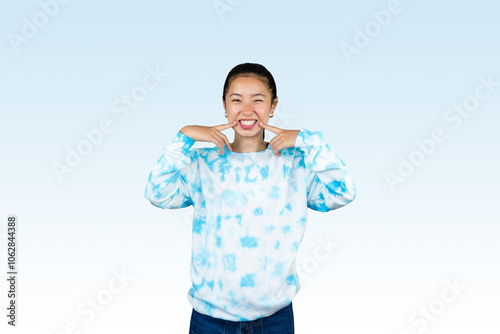 Yougn Asian girl with blue dress points and gives various expression and gestures isolated happy sad photo