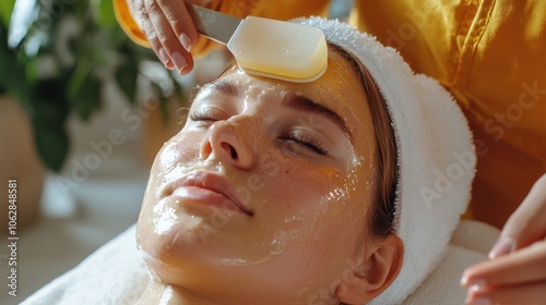 Skincare specialist applies gua sha tool for facial rejuvenation photo