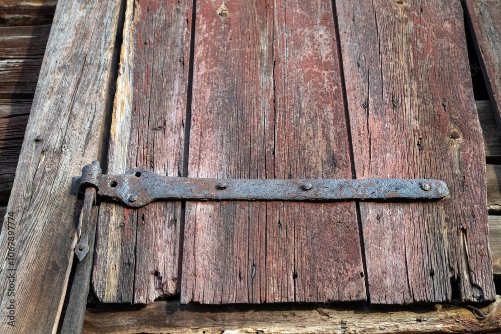 Obraz premium old shutter with rusty hinge in a barn