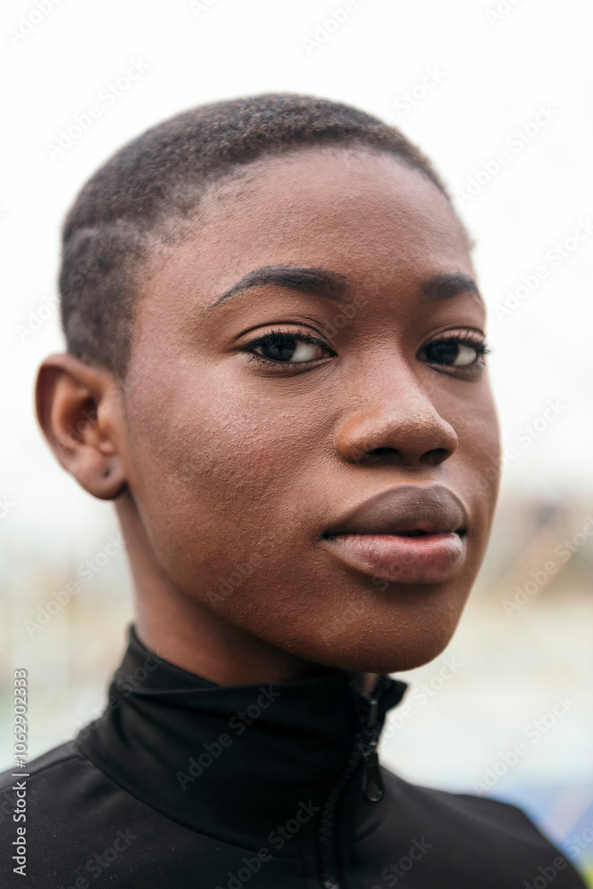 Obraz premium close up portrait of a young tender ethnic female with short hair looking at camera with blurred background