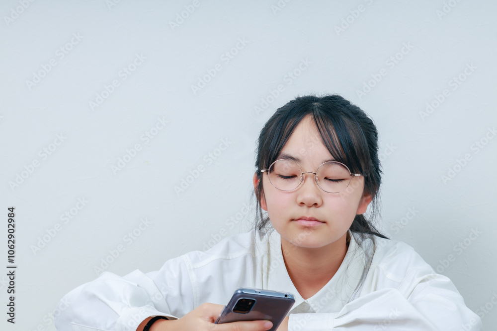 スマホを操作する女の子|左スペース スマホを操作する女の子|左スペース
