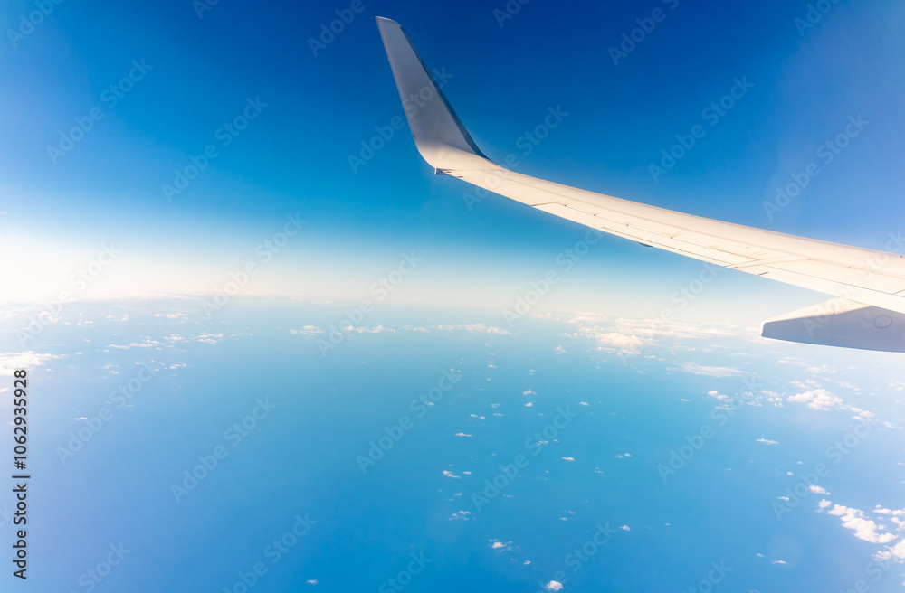 View from the airplane window at a beautiful blue clear sky and the airplane wing View from the airplane window at a beautiful blue clear sky and the airplane wing