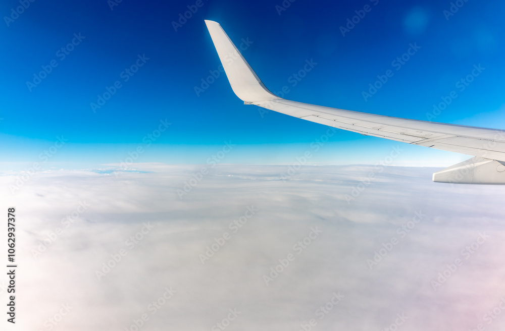 View from the airplane window at a beautiful cloudy sky and the airplane wing View from the airplane window at a beautiful cloudy sky and the airplane wing