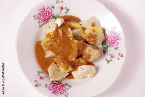 a siomay with fish balls, potatoes, peanut sausage, and tofu on a white background isolated