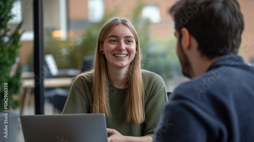 Happy young employee woman talking to male coworker.