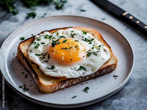 A fried egg on toast with herbs.